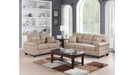 Shelton tan sofa and loveseat in a living room with bookshelves, wider view